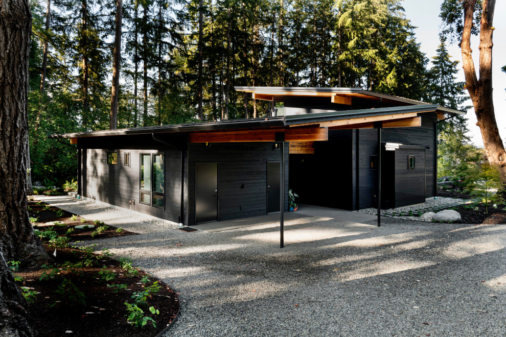 Imagen de fachada de casa negra y negra escandinava de tamaño medio de dos plantas con revestimiento de madera, tejado de un solo tendido y tejado de metal