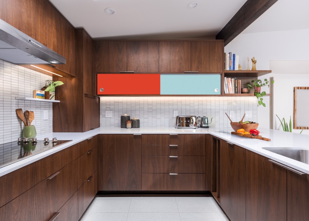 This is an example of a mid-sized midcentury u-shaped eat-in kitchen in Sacramento with a single-bowl sink, flat-panel cabinets, dark wood cabinets, quartz benchtops, white splashback, ceramic splashback, stainless steel appliances, porcelain floors, a peninsula, white floor, white benchtop and exposed beam.