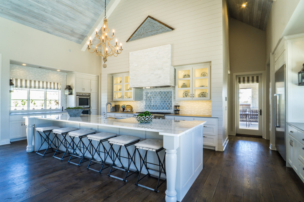 Inspiration for a large country kitchen in Austin with an undermount sink, white cabinets, marble benchtops, stainless steel appliances, dark hardwood floors, with island, brown floor, multi-coloured splashback and glass-front cabinets.