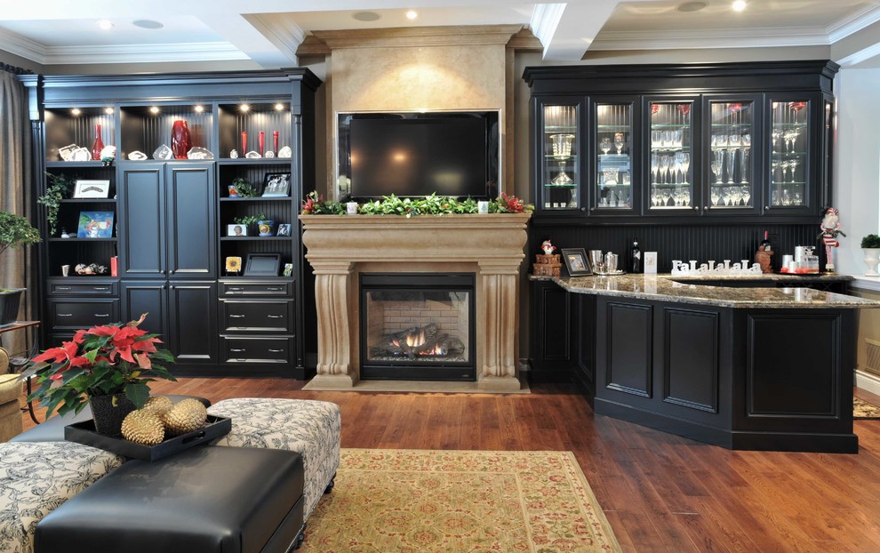 Photo of a large traditional enclosed living room in Other with a home bar, white walls, medium hardwood floors, a standard fireplace, a stone fireplace surround, a built-in media wall and brown floor.