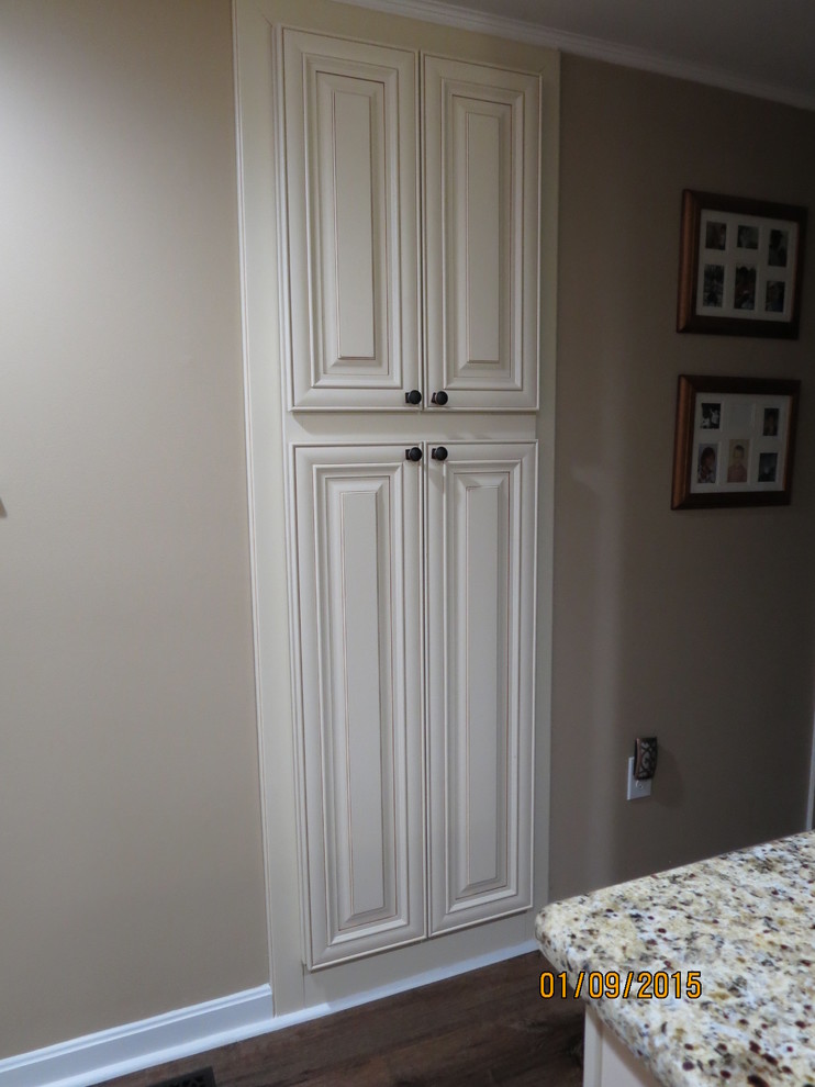 Inspiration for a mid-sized u-shaped eat-in kitchen remodel in DC Metro with a double-bowl sink, raised-panel cabinets, white cabinets, granite countertops, beige backsplash, porcelain backsplash and stainless steel appliances