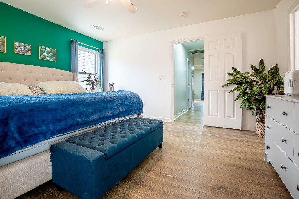 This is an example of a medium sized nautical master bedroom in Nashville with white walls, vinyl flooring and brown floors.