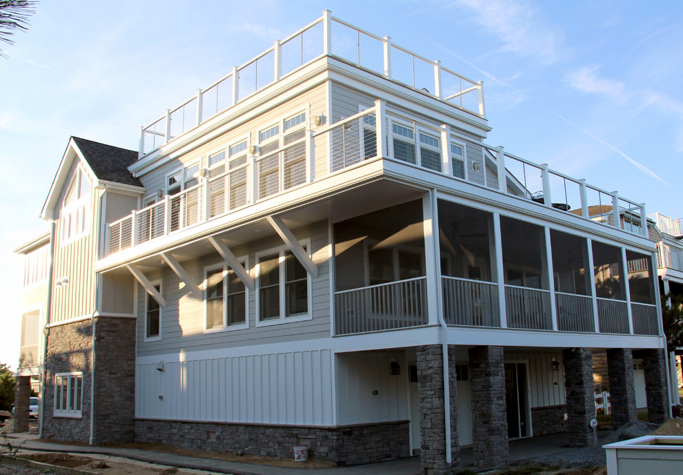 Inspiration for a large beach style three-storey grey exterior in Other with concrete fiberboard siding.