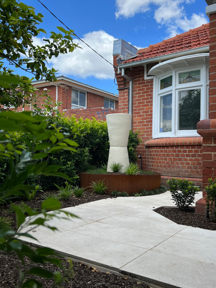 Ispirazione per un piccolo giardino design esposto in pieno sole davanti casa in primavera con un ingresso o sentiero, pavimentazioni in pietra naturale e recinzione in metallo