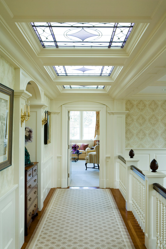 This is an example of a traditional hallway in Boston with white walls and medium hardwood floors.