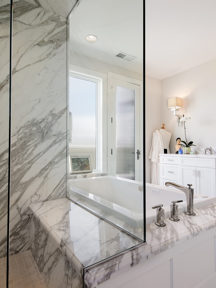Traditional bathroom in Denver with a drop-in tub and marble.