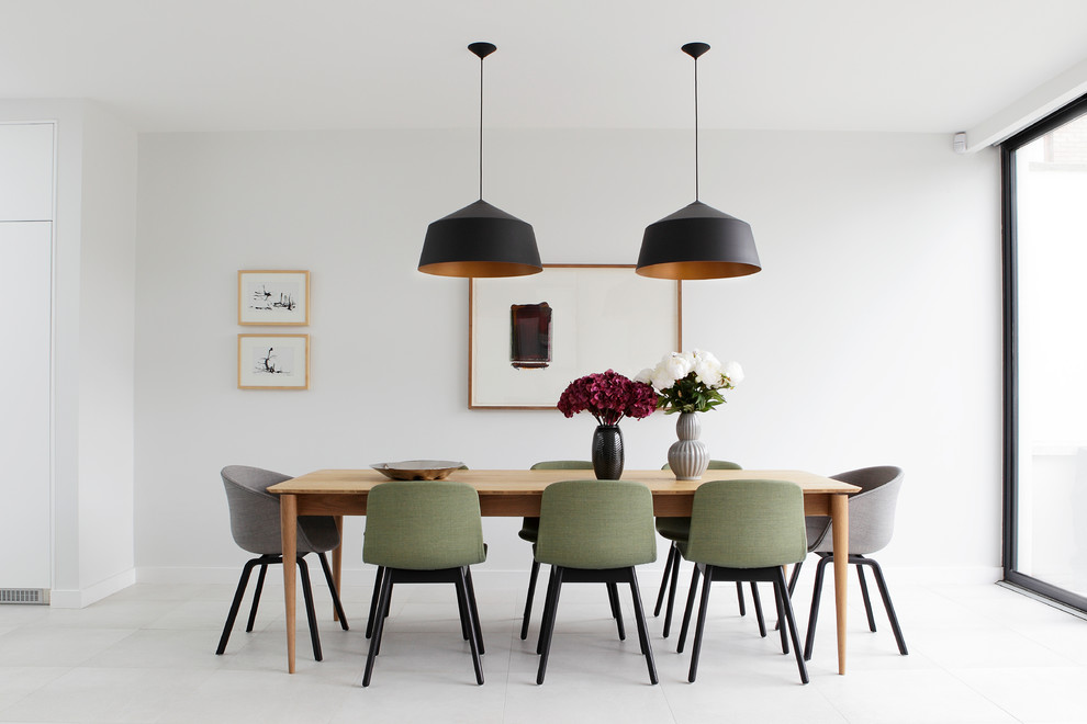 Mid-sized modern dining room in Dublin with white walls.