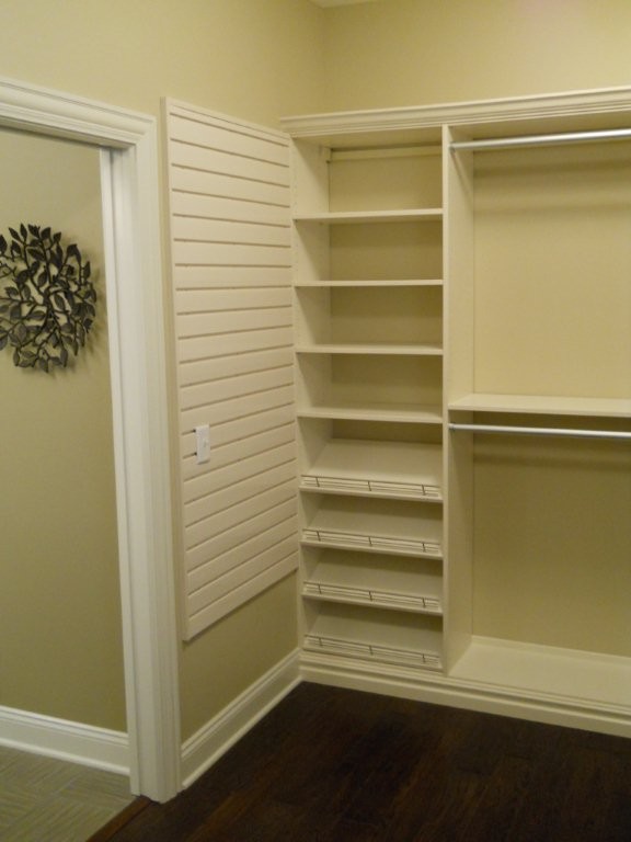 Photo of a mid-sized transitional women's walk-in wardrobe in Cleveland with raised-panel cabinets and white cabinets.
