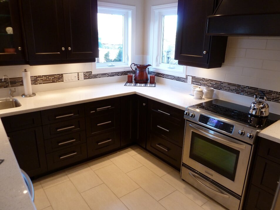 Transitional porcelain tile and beige floor eat-in kitchen photo in Toronto with a double-bowl sink, shaker cabinets, dark wood cabinets, quartz countertops, white backsplash, subway tile backsplash, stainless steel appliances and white countertops