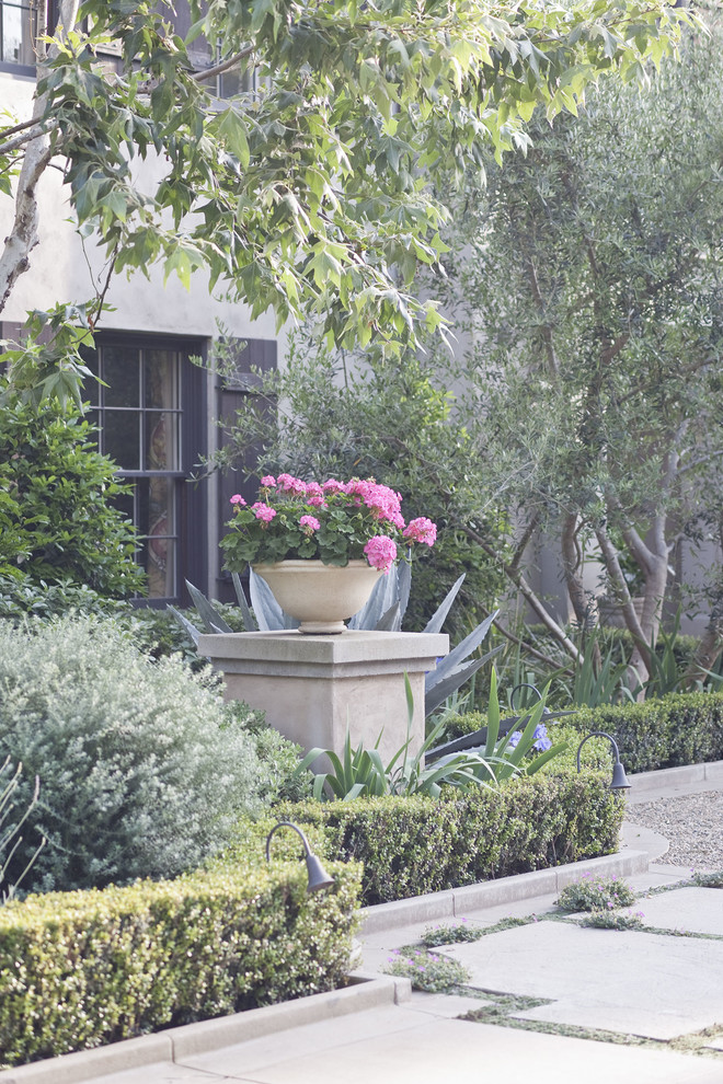 Inspiration for a large mediterranean front yard full sun driveway in Los Angeles with a water feature and gravel.