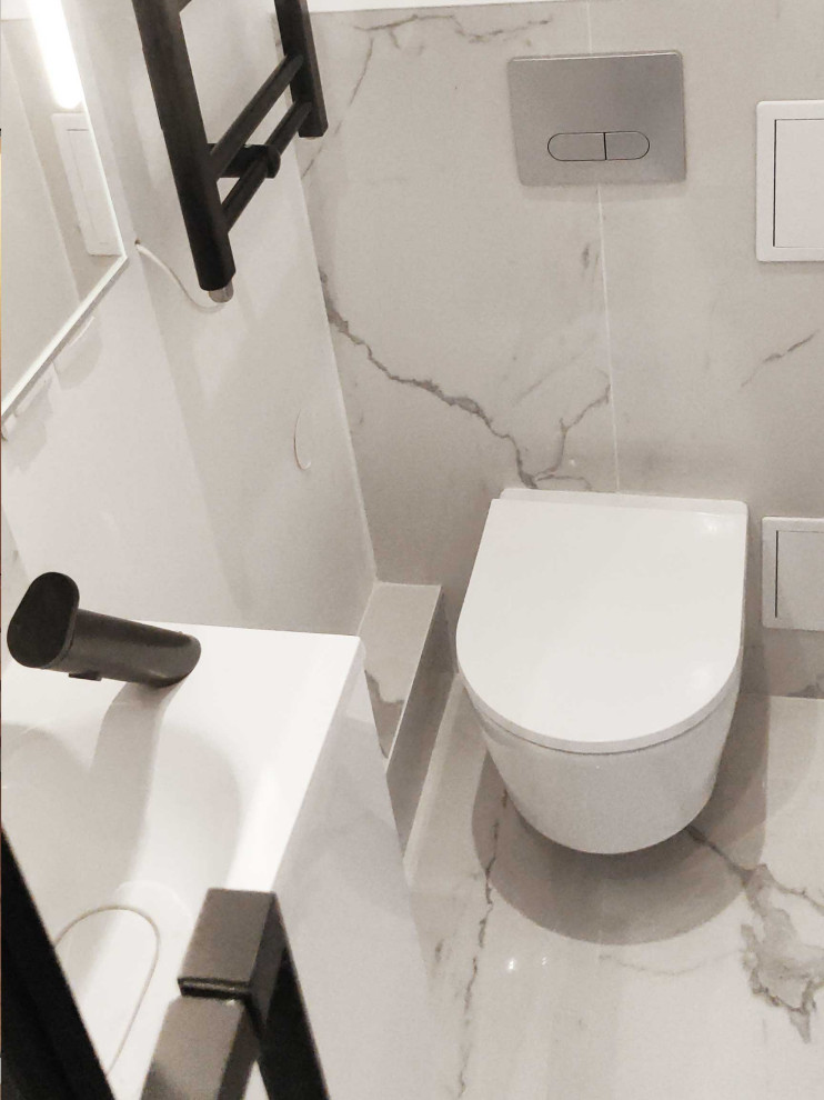 Photo of a small contemporary powder room in Paris with beaded inset cabinets, white cabinets, a wall-mount toilet, white tile, marble, white walls, marble floors, a wall-mount sink, solid surface benchtops, white floor, white benchtops and a floating vanity.