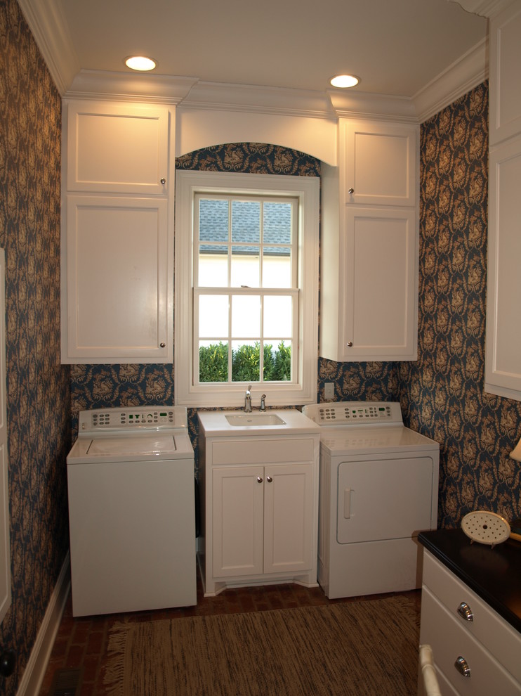 Design ideas for a traditional utility room in Nashville with shaker cabinets, white cabinets, blue walls, brick floors and a side-by-side washer and dryer.