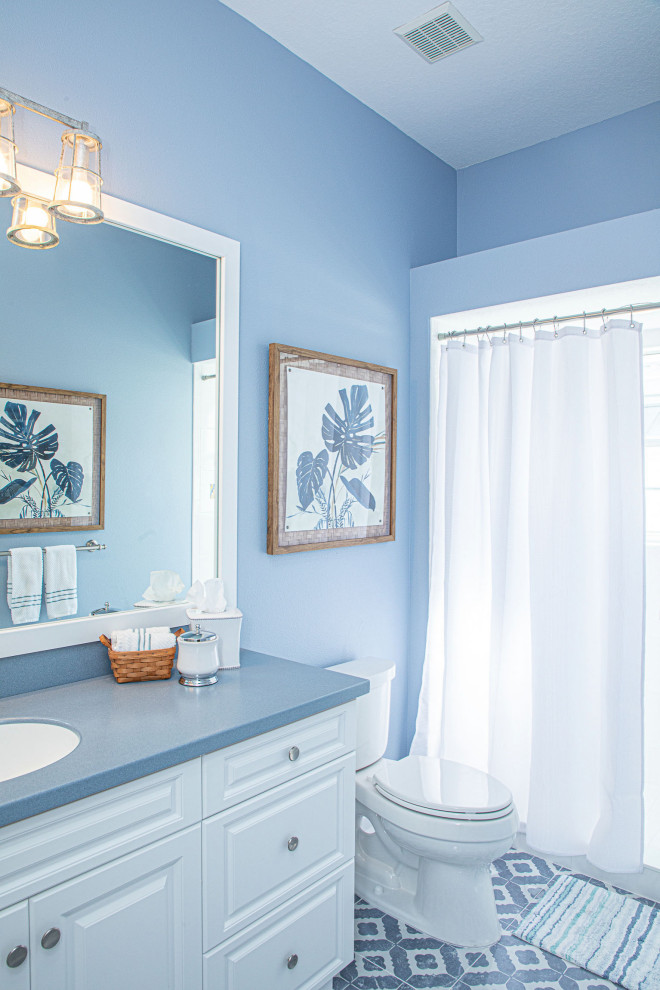 Inspiration for a mid-sized beach style 3/4 wet room bathroom in Tampa with a one-piece toilet, an undermount sink, a shower curtain, a single vanity and a built-in vanity.