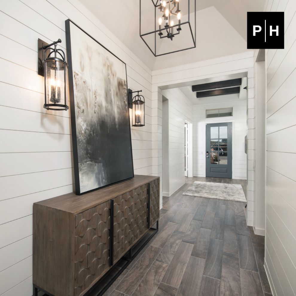 Idée de décoration pour une entrée avec un couloir, un mur blanc, un sol en bois brun, une porte simple, une porte grise, un plafond voûté et du lambris de bois.
