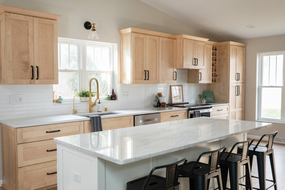 Exempel på ett mellanstort modernt vit vitt kök, med en nedsänkt diskho, skåp i shakerstil, skåp i ljust trä, bänkskiva i kvarts, vitt stänkskydd, stänkskydd i keramik, rostfria vitvaror, ljust trägolv, en köksö och brunt golv
