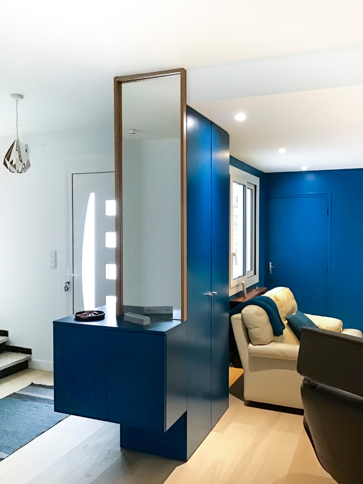Exemple d'un salon tendance de taille moyenne et ouvert avec un mur bleu, parquet clair et éclairage.