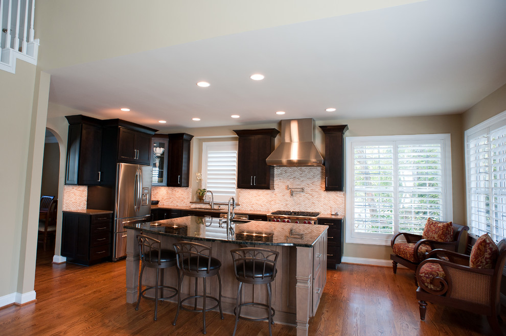 Kitchen - mid-sized transitional l-shaped kitchen idea in Charlotte with dark wood cabinets, granite countertops, white backsplash and an island