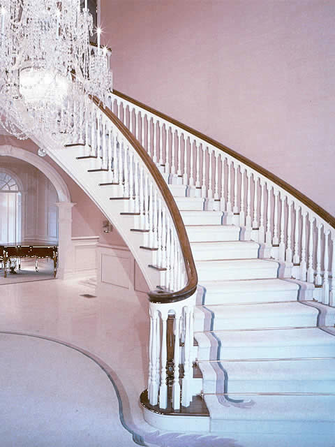 Example of a large classic wooden curved staircase design in DC Metro with painted risers