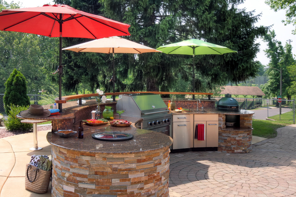 Large contemporary backyard patio in St Louis with an outdoor kitchen, concrete pavers and no cover.