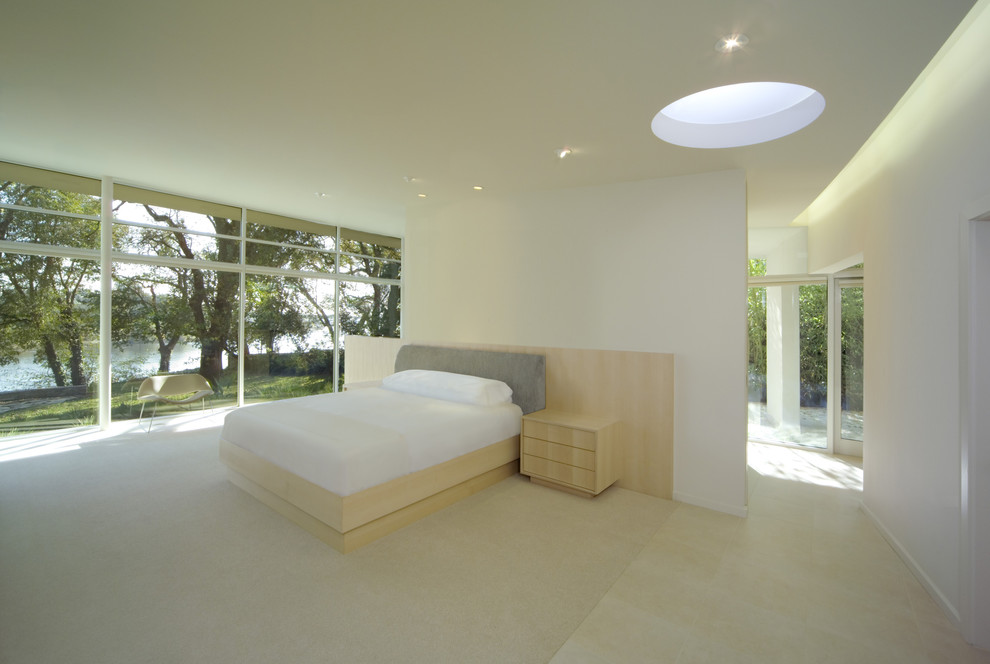 This is an example of a large modern master bedroom in San Francisco with beige walls, limestone floors and no fireplace.