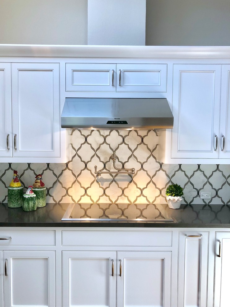 Photo of a large traditional u-shaped kitchen in San Francisco with beaded inset cabinets, white cabinets, quartz benchtops, multi-coloured splashback, stone tile splashback, with island and brown benchtop.