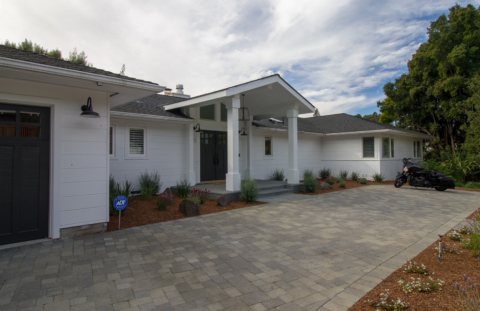 Réalisation d'une façade de maison blanche minimaliste en panneau de béton fibré de taille moyenne et de plain-pied avec un toit à quatre pans, un toit en shingle et un toit noir.