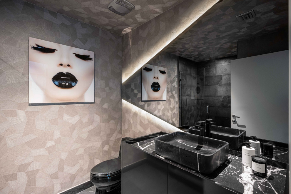 Medium sized contemporary cloakroom in Miami with flat-panel cabinets, black cabinets, a one-piece toilet, black tiles, limestone tiles, grey walls, limestone flooring, a vessel sink, marble worktops, grey floors, black worktops, a built in vanity unit, a wallpapered ceiling and wallpapered walls.