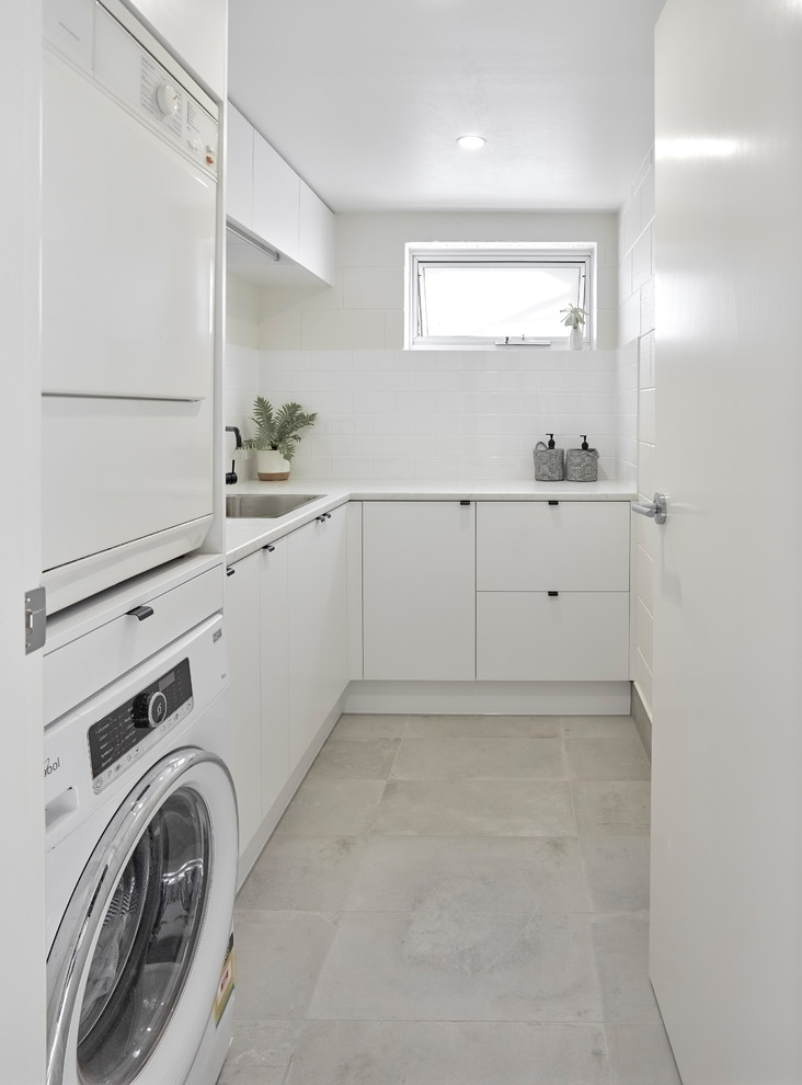Mid-sized contemporary laundry room in Other with white cabinets, white walls, porcelain floors, grey floor and flat-panel cabinets.