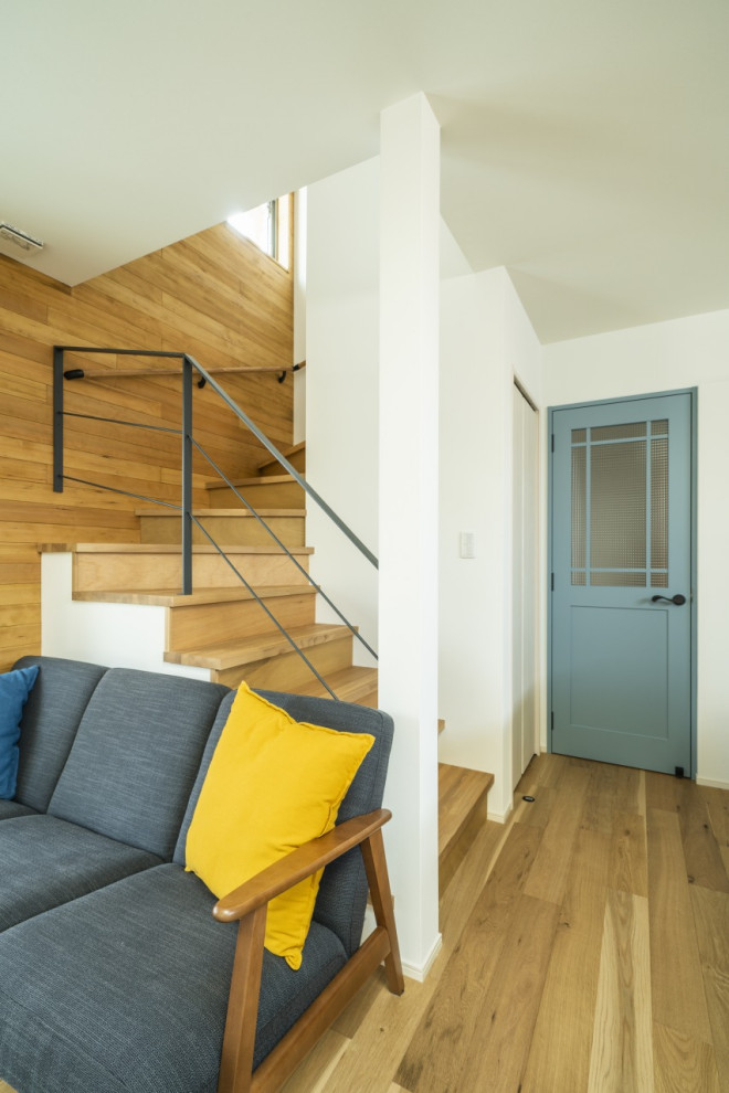 Aménagement d'un escalier courbe moderne de taille moyenne avec des marches en bois, des contremarches en bois, un garde-corps en bois, du papier peint et rangements.