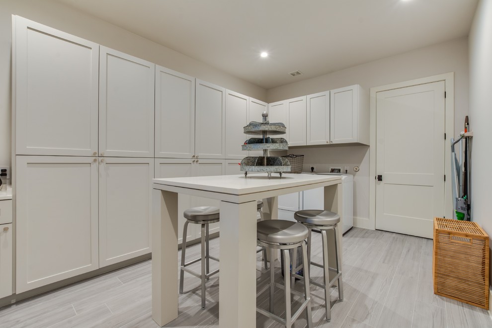 Photo of a mid-sized transitional l-shaped dedicated laundry room with an undermount sink, shaker cabinets, white cabinets, quartz benchtops, white walls, a side-by-side washer and dryer and white benchtop.