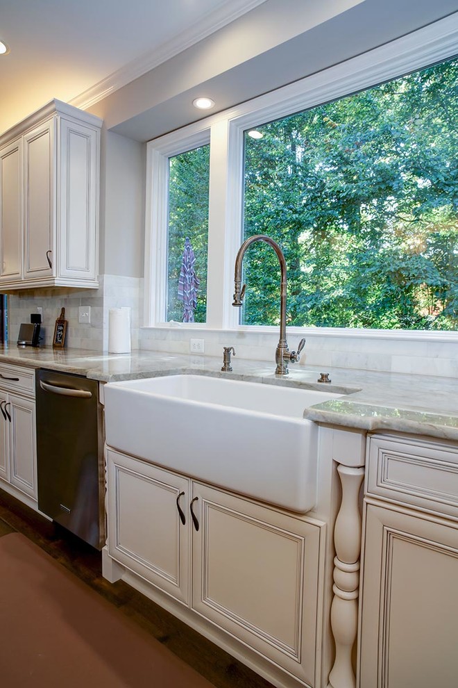 Example of a transitional u-shaped dark wood floor eat-in kitchen design in Cedar Rapids with a farmhouse sink, flat-panel cabinets, white cabinets, marble countertops, stainless steel appliances and an island
