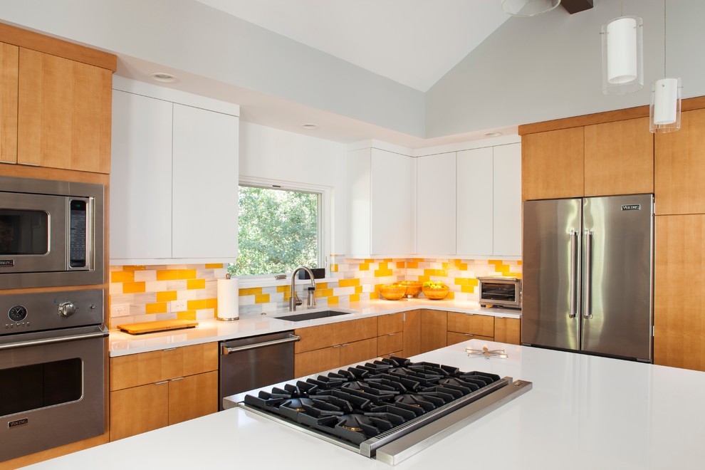 Photo of a midcentury l-shaped eat-in kitchen in Atlanta with a single-bowl sink, flat-panel cabinets, light wood cabinets, quartzite benchtops, yellow splashback, glass tile splashback and stainless steel appliances.