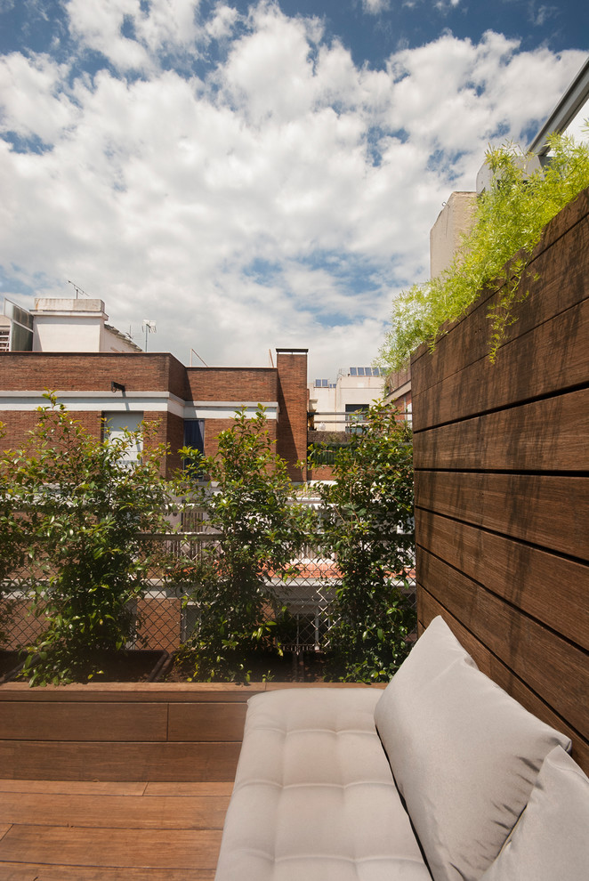 Mid-sized tropical rooftop deck in Barcelona with a container garden and no cover.