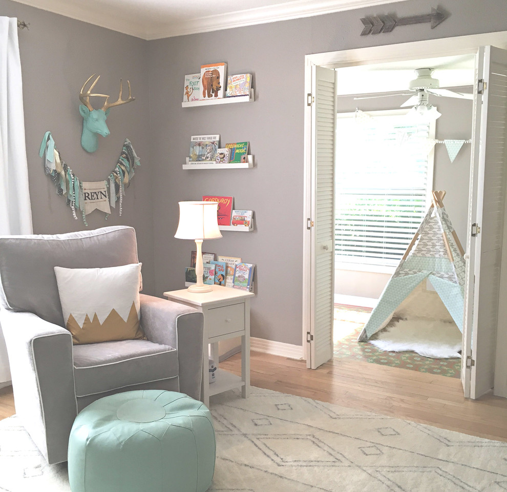 This is an example of a large transitional nursery for boys in Austin with grey walls and light hardwood floors.