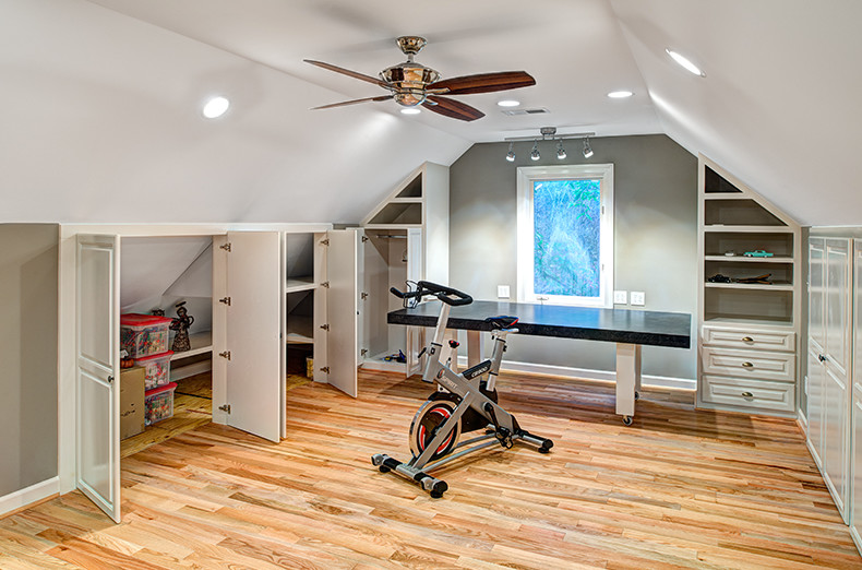 Photo of a home gym in Other with green walls and light hardwood floors.