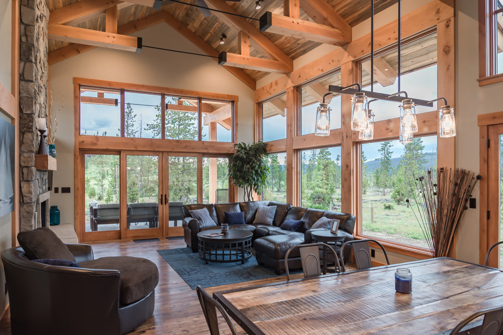 Mid-sized country open concept living room in Denver with light hardwood floors, a standard fireplace, a stone fireplace surround and a wall-mounted tv.