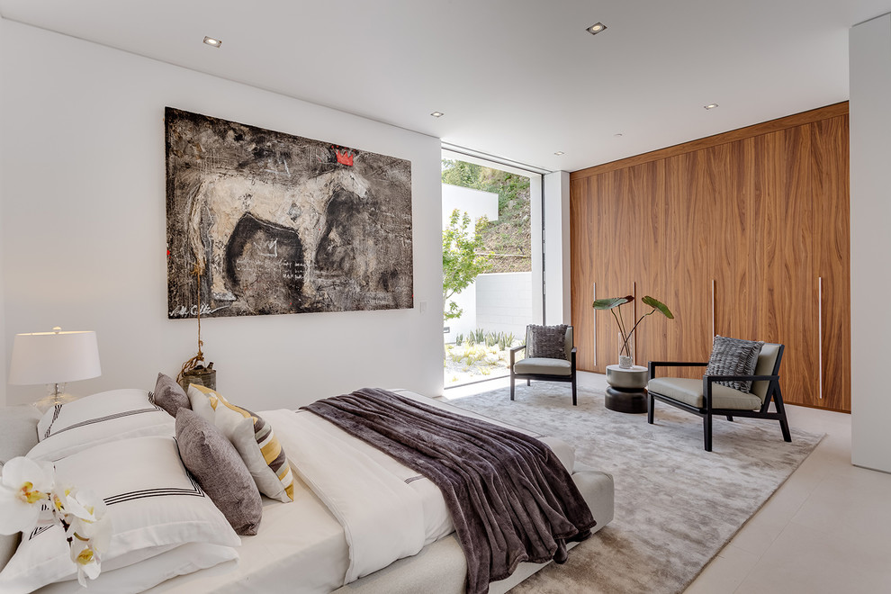 This is an example of a large contemporary bedroom in Los Angeles with white walls, ceramic floors and beige floor.