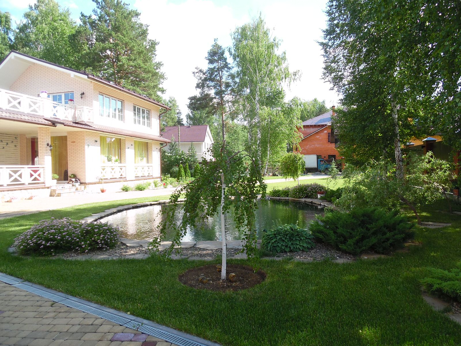 Современный сад с большим прудом.