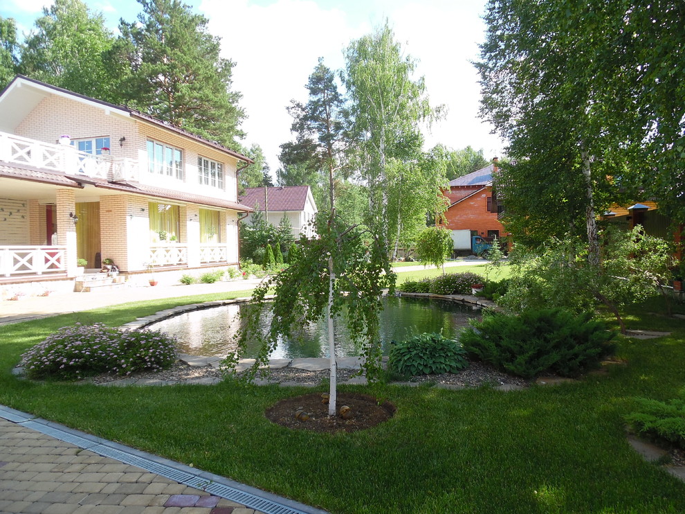 Современный сад с большим прудом.