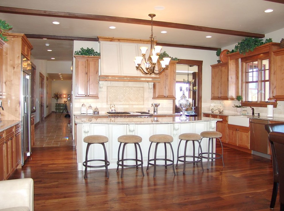 Inspiration for a large transitional u-shaped dark wood floor eat-in kitchen remodel in Denver with a farmhouse sink, raised-panel cabinets, granite countertops, beige backsplash, mosaic tile backsplash, stainless steel appliances and an island