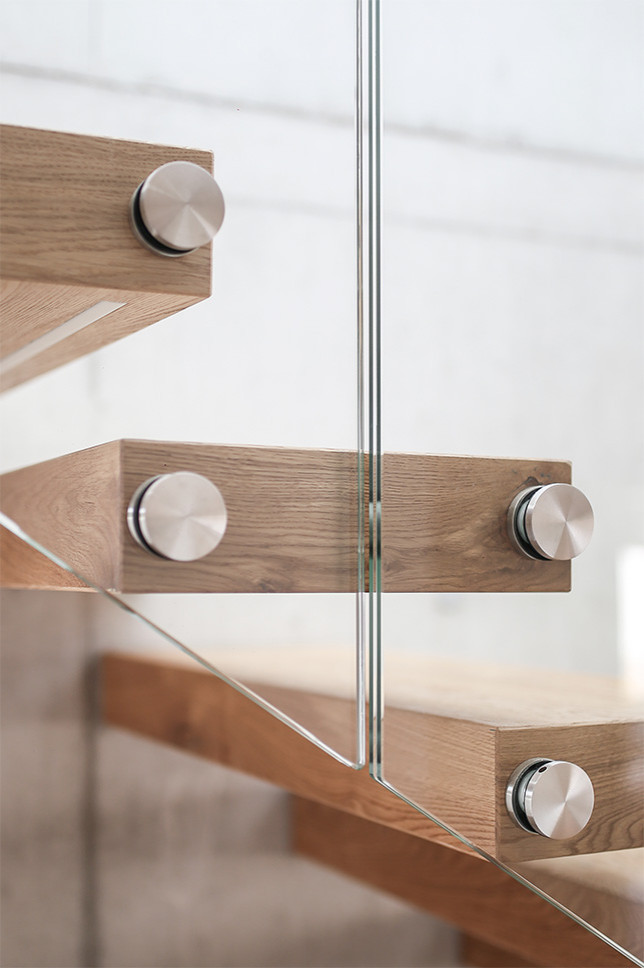 Imagen de escalera suspendida minimalista con escalones de madera y barandilla de vidrio