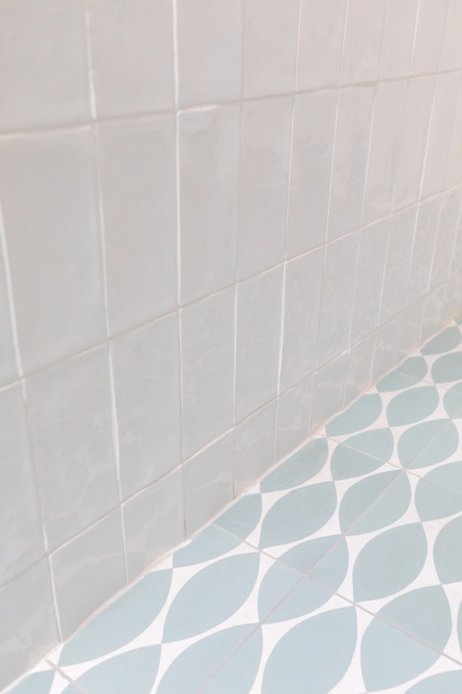 Idéer för att renovera ett stort shabby chic-inspirerat beige beige en-suite badrum, med släta luckor, svarta skåp, ett platsbyggt badkar, en dusch/badkar-kombination, en vägghängd toalettstol, vit kakel, perrakottakakel, vita väggar, cementgolv, ett avlångt handfat, träbänkskiva, blått golv och med dusch som är öppen