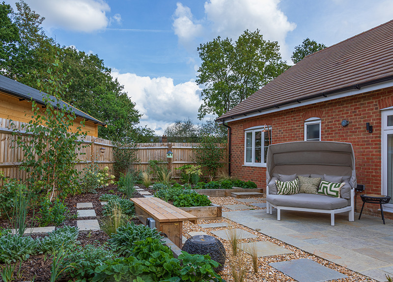 Esempio di un piccolo giardino country esposto in pieno sole dietro casa in estate con pavimentazioni in pietra naturale e recinzione in legno