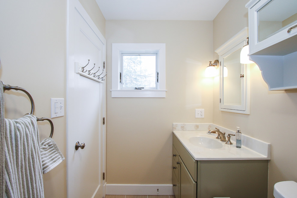 Small beach style master bathroom in Baltimore with shaker cabinets, green cabinets, an alcove shower, a two-piece toilet, green tile, cement tile, beige walls, ceramic floors, an integrated sink, engineered quartz benchtops, orange floor and a shower curtain.