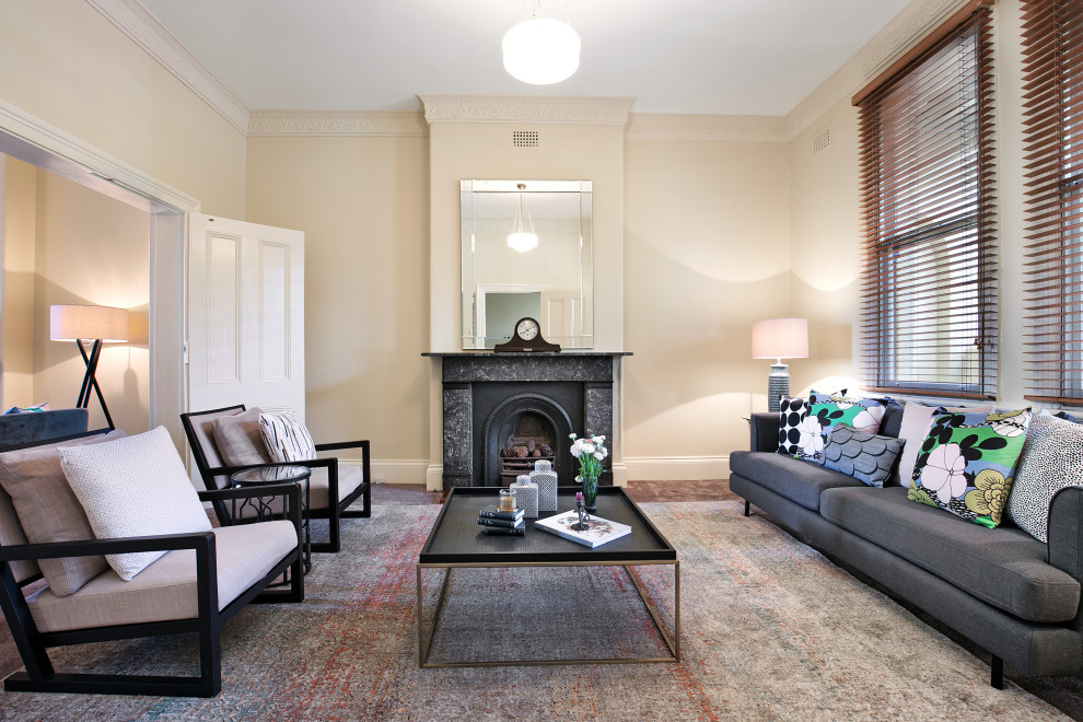This is an example of a transitional formal open concept living room in Sydney with carpet, a standard fireplace, a stone fireplace surround, no tv, beige walls and brown floor.
