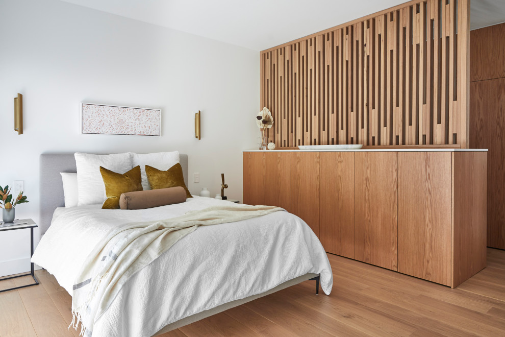 Photo of a mid-sized contemporary master bedroom in Sydney with white walls and light hardwood floors.