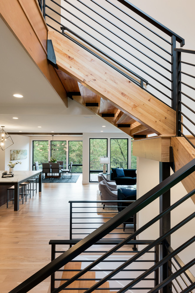 This is an example of a large modern wood u-shaped staircase in Minneapolis with open risers and metal railing.