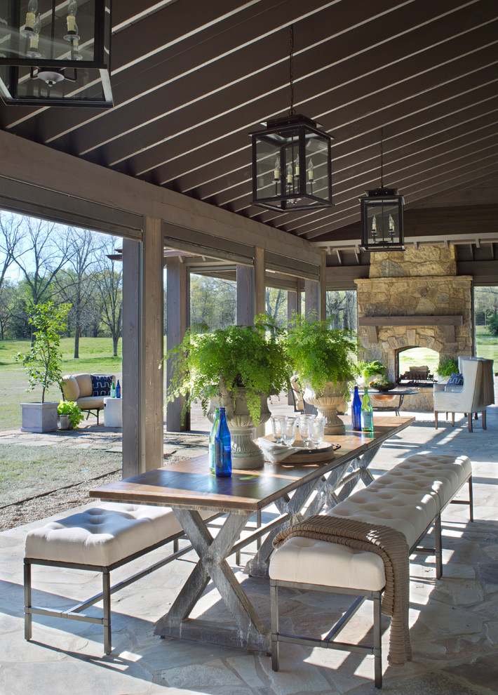Design ideas for a country backyard patio in Austin with a fire feature, natural stone pavers and a roof extension.