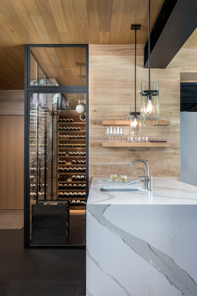 Mid-sized mountain style gray floor wine cellar photo with display racks