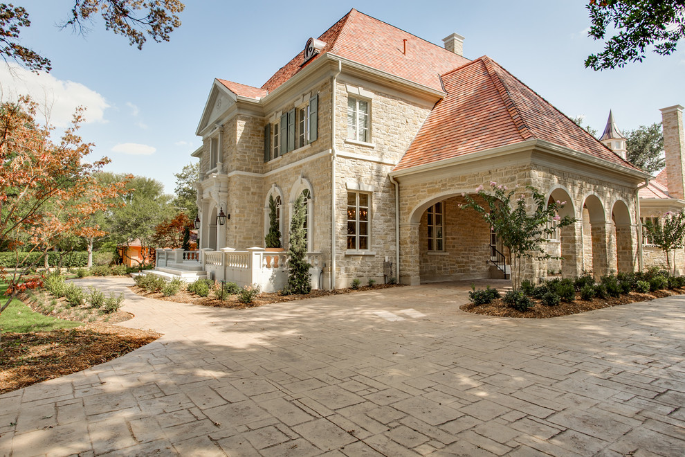 Large traditional two-storey exterior in Dallas with stone veneer.